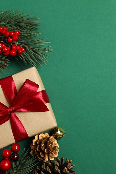 istock Bright festive vertical scene with wrapped gift and decorations on a green background, Christmas and New Year holiday 2248043562