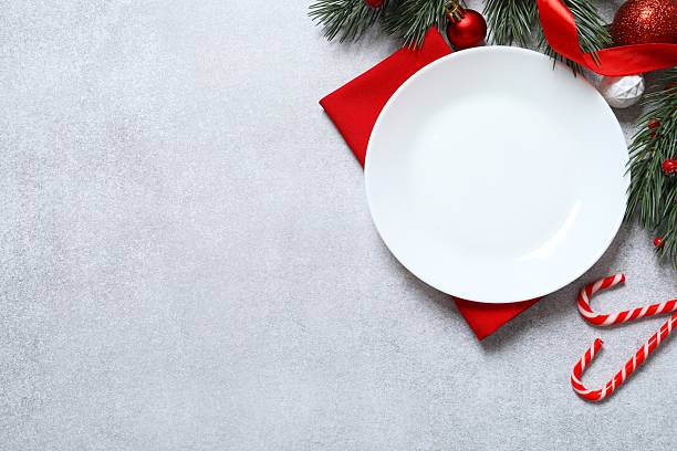 istock Festive Christmas and New Year's tablescape with pine branches, ornaments and elegant dinnerware on light background. Perfect for holiday greetings 2248043641