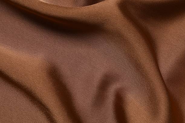 istock Brown silk satin. Shiny smooth fabric. Soft folds. Luxury background with space for design. Flat table, top view 2248046198