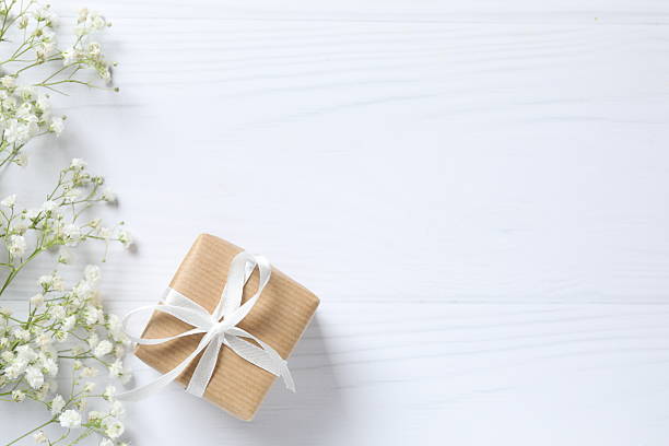 istock White gypsophila flowers and gift box on light background with empty space 2248046470