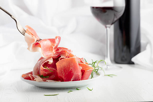 istock Prosciutto with rosemary and  red wine on a white wooden table. 2248047321