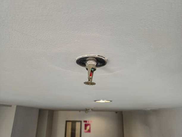 istock Recessed fire sprinkler head with red bulb on a white ceiling, essential safety equipment 2248051489