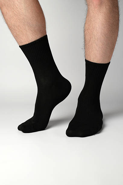 istock Man's legs in black athletic socks on a white background 2248052540