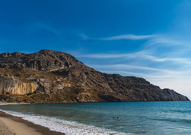 istock Waves crashing on the sandy beach in the bay between the hills 2248053273