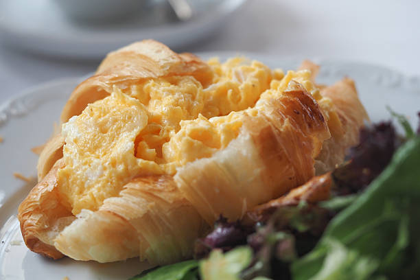 istock Croissant with scrambled eggs and greens at cafe 2248053973