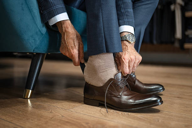 istock Mature Man Trying on Leather Shoes in Upscale Store 2248054924