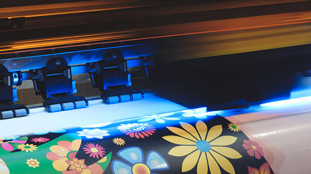istock A moving working industrial wide format printer prints a color picture on paper 2248055677