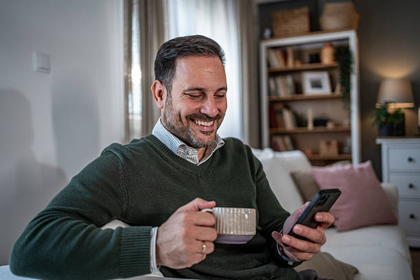 istock Mid-adult man relaxing at home using smartphone 2248058493