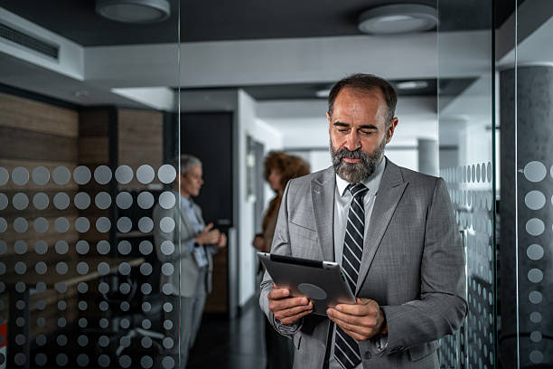 istock Mature businessman reading digital tablet in modern office 2248059643