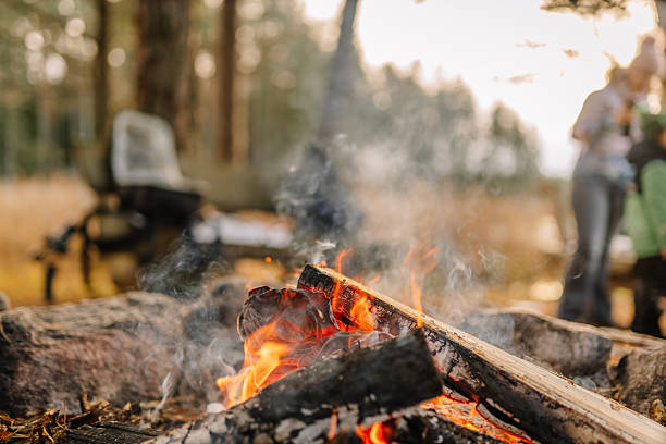 istock Campfire with glowing flames and smoke rising, surrounded by rocks in a serene forest setting, capturing the essence of outdoor adventure and warmth 2248066342