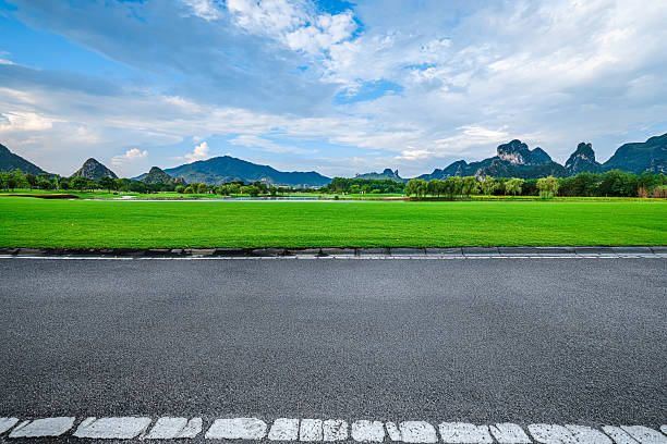 istock Empty asphalt road and green grass field with mountain. 2248066816