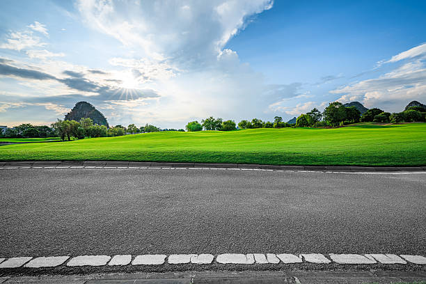 istock Empty asphalt road side with green grass field and mountain landscape at sunset. 2248066830
