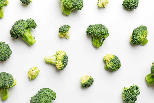 istock green fresh broccoli background close up on colored table. Vegetables for diet and healthy eating. Organic food 2248073760