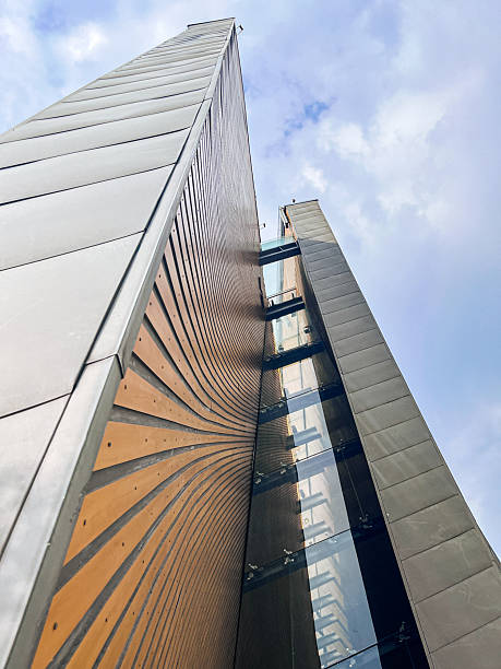 istock Modern architectural facade with dynamic curved metal panels and glass reflections looking upward 2248075445