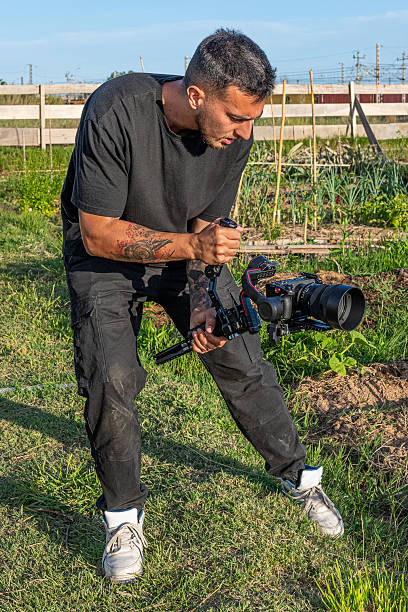 istock Videographer recording with a camera and gimbal in a community garden 2248075537