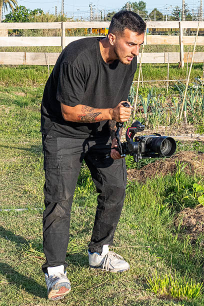 istock Videographer filming in a community garden using a professional camera and gimbal 2248075538