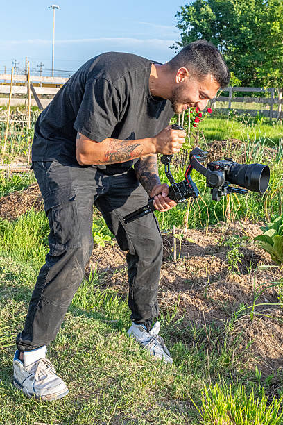 istock Videographer filming in a community garden using a Ronin gimbal and camera 2248075547