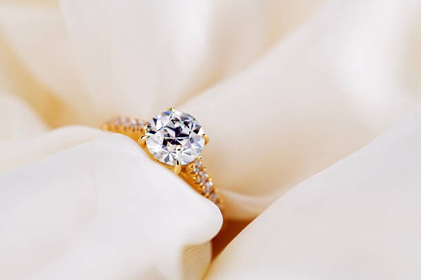 istock A gold and white diamond ring is on a white cloth 2248081819