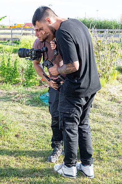 istock Two videographers using a gimbal and a professional camera are working outdoors 2248083713