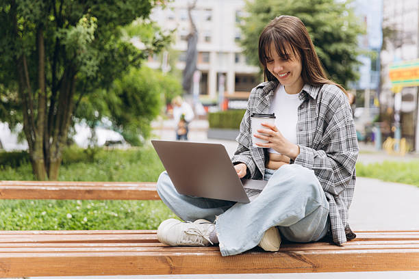 istock Woman working remotely on laptop at park bench 2248084753