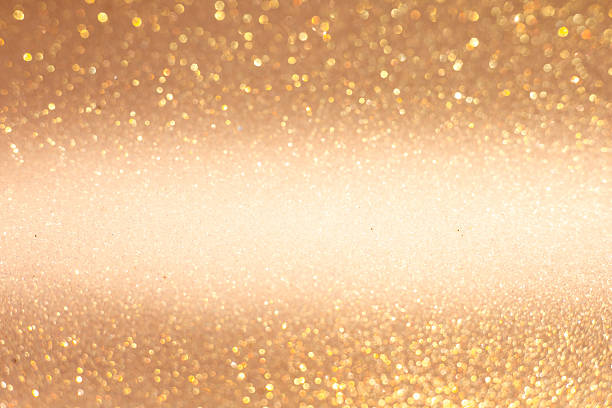 Abstract blurred background with golden glitter. Soft focus creates a dreamy effect, ideal for holiday themes like Christmas and New Year.