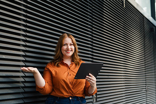 istock Curvy adult woman holding tablet, reading something. 2248091020