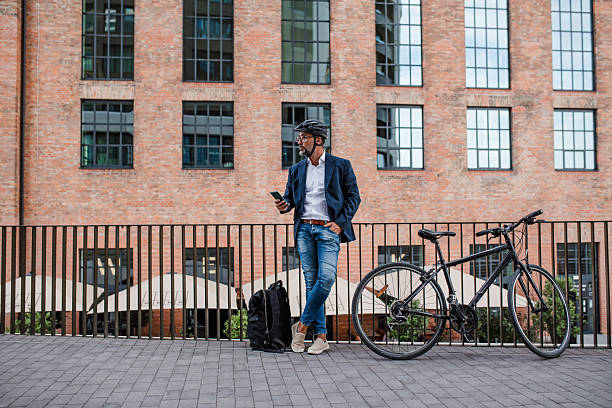 istock City commuter riding bike from work, reading text message on phone. 2248091341