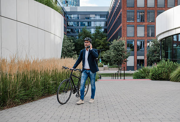 istock Male cyclist making phone call, walking by his bike. 2248092201