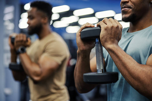istock Two men doing bicep curls with dumbbells in gym 2248093274
