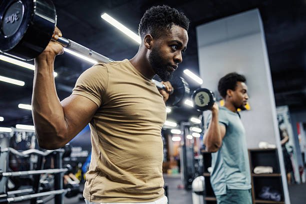 istock Two young men working out with barbells in gym 2248093493