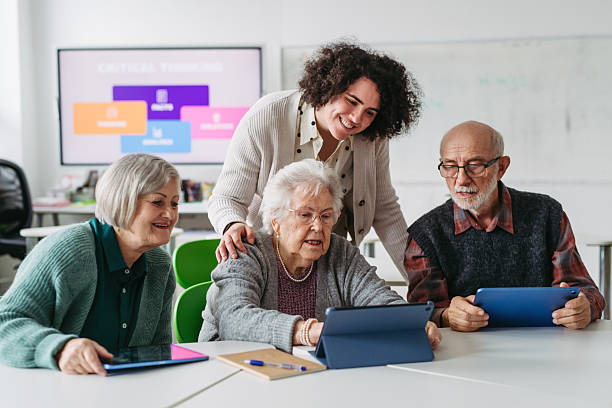 istock Group of seniors learning digital skills with tutor support in community center. 2248094653