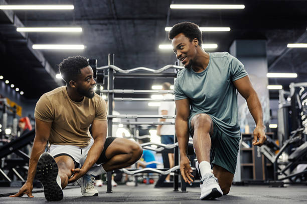 istock Two men talking, exercising and stretching in gym 2248095025