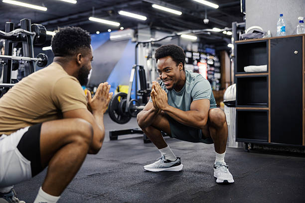 istock Two men squatting during a workout at the gym, smiling 2248095042