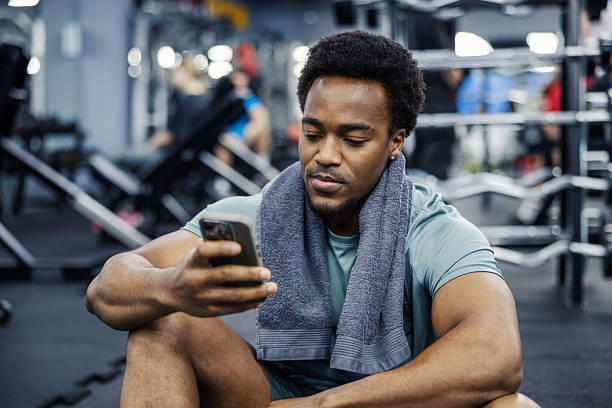 istock Young adult man checking smartphone resting during gym workout 2248095202