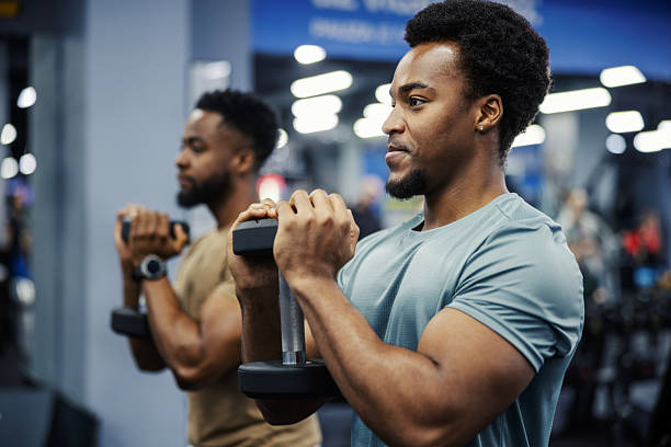 istock Young adult men lifting weights at gym 2248096056