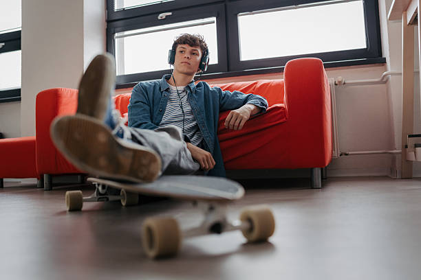 istock High school student chilling with headphones. 2248096100