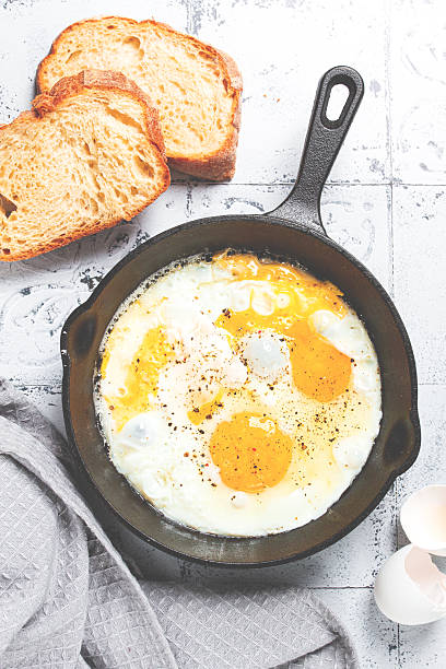 Freshly cooked eggs in a pan, served with bread, on the kitchen counter,breakfast, natural light, no people,