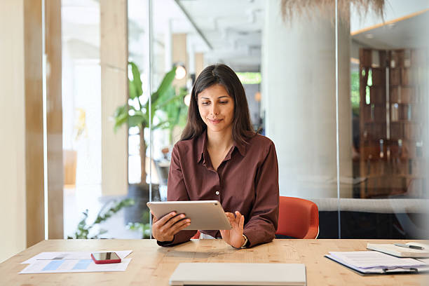 istock Successful smiling latin hispanic young woman using pad computer for business app. Busy executive CEO businesswoman professional holding digital tablet pc device for work in modern office workplace. 2248098571