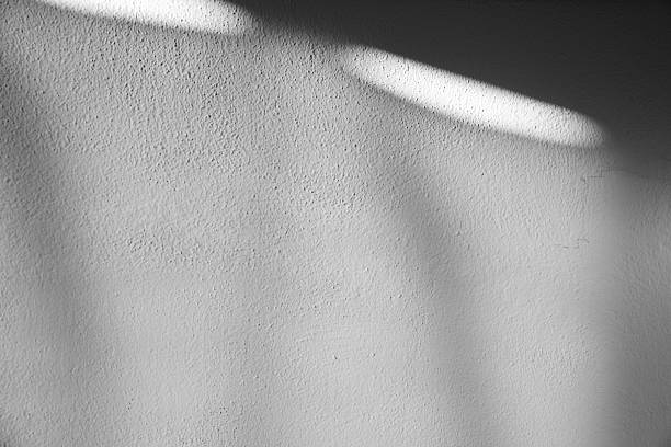 istock Detailed minimalist background with soft natural shadows cast on textured white wall surface 2248100495