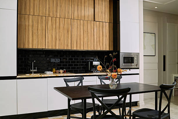 istock Modern Kitchen Interior Featuring Black Table and Decorative Flower Arrangement 2248103334