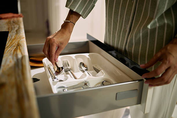 istock Middle Aged Woman Organizing Cutlery in Kitchen Drawer 2248105053