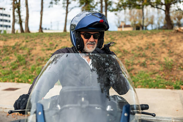 istock Senior man riding motorcycle talking on phone 2248106397