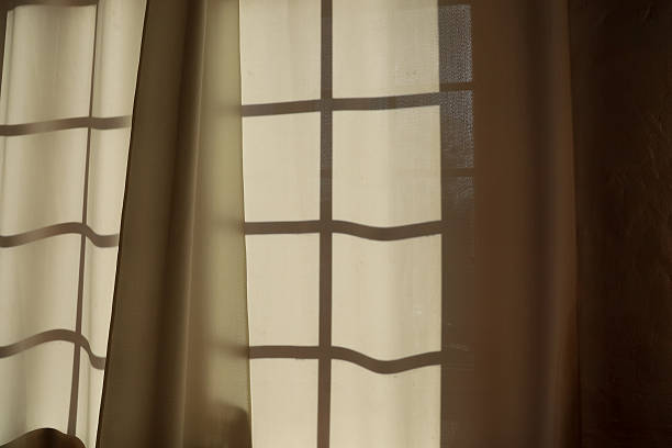 istock Sunlight casting soft shadows through sheer curtains in a calm room during the day 2248106735