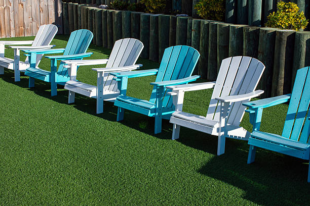 four outdoors Adirondack chairs colors white and aqua blue on green turf