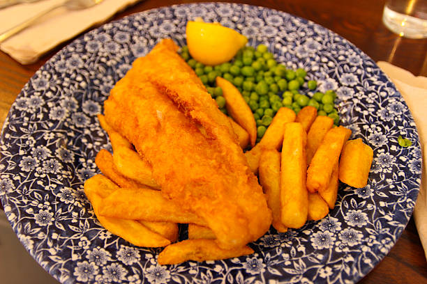 Breaded cod fillets with new potatoes and peas.