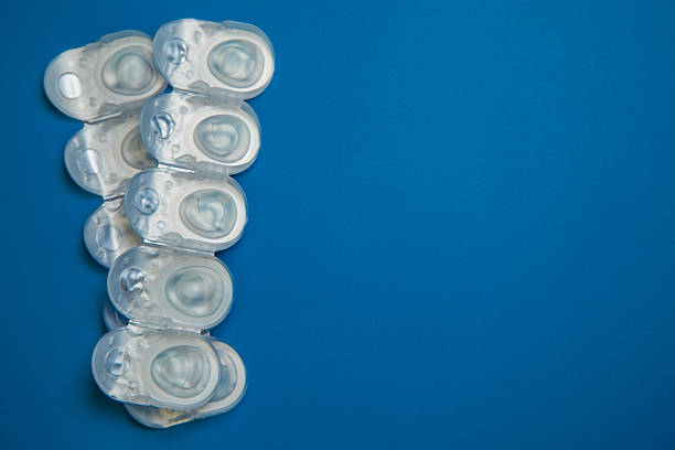 istock Many daily contact lenses in a disposable protective case in which clear lenses float lie on the side on a blue background with space for text. The concept of ophthalmology, vision correction, eye care. 2248115346