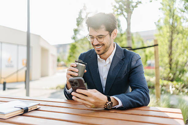 istock Professional man smiling checking phone having coffee break outdoors 2248123151
