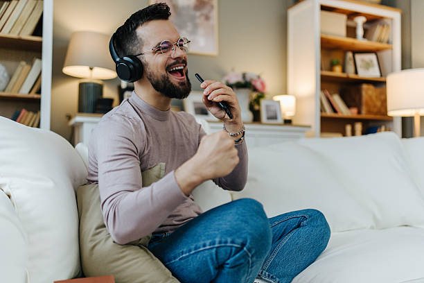 istock Man singing with phone and headphones at home 2248123619
