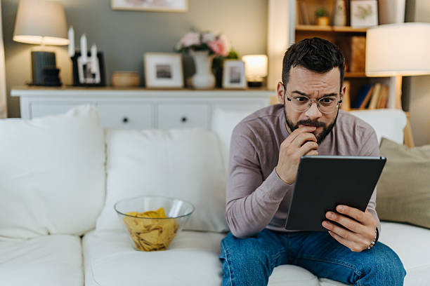 istock Stressed man watching content on digital tablet at home 2248123669