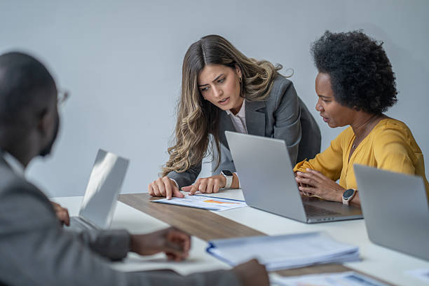 istock Businesswomen analyzing charts and working on laptops in a meeting 2248127611